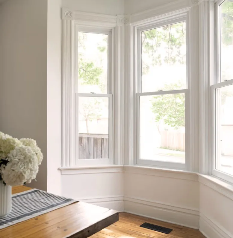 A bay of white Marvin wood-clad double-hung windows in a sunlit room