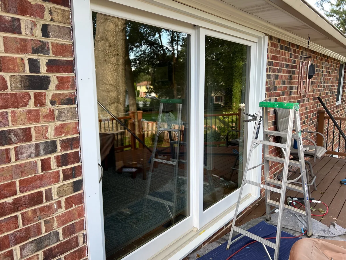 A new white Marvin sliding glass door in a brick wall